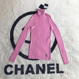 La blusa de la Sra. Louis Vuitton es un suéter de cuello alto rosa.